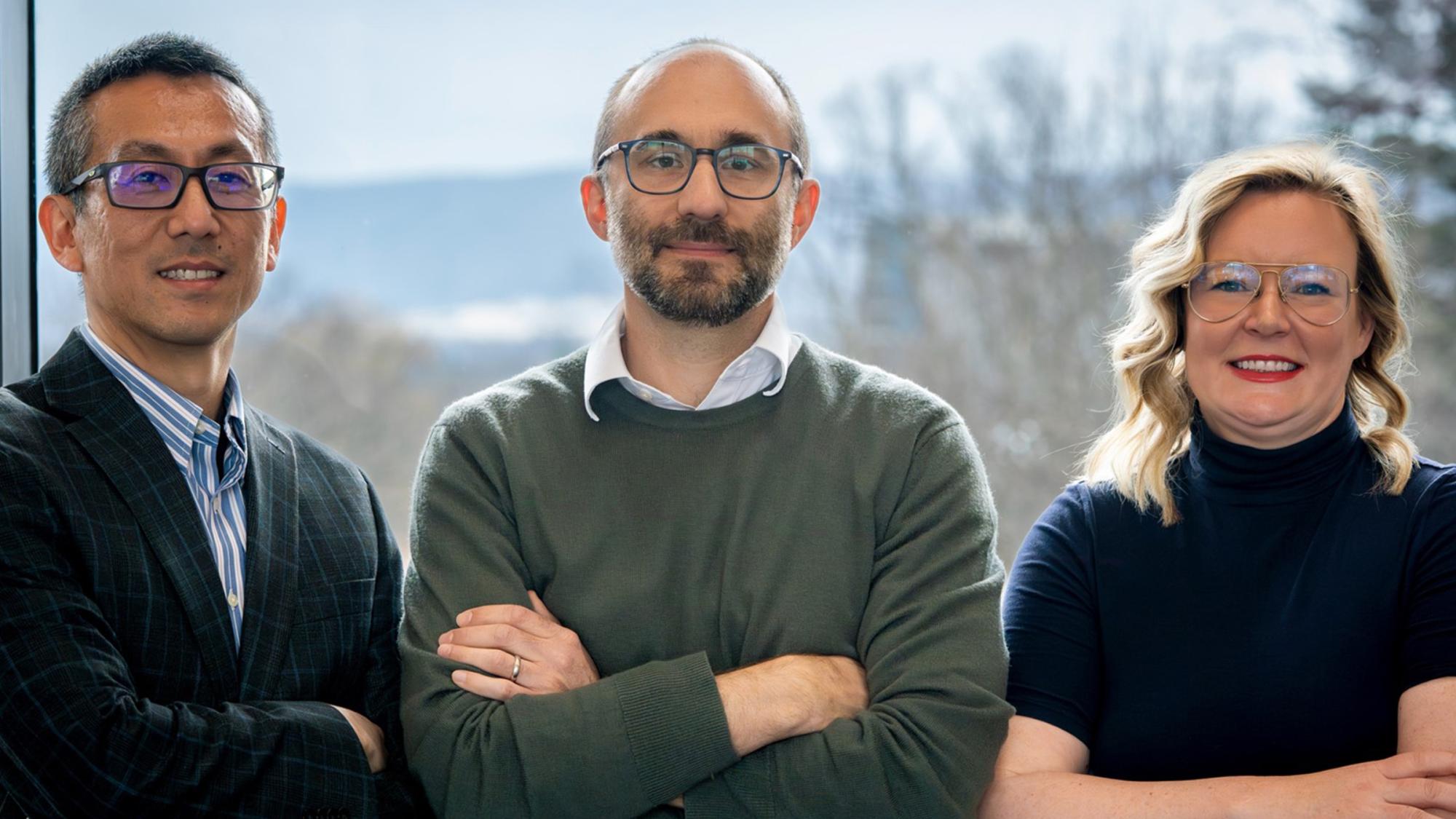 Three people crossing their arms pose for a photo.