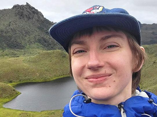 A dual degree environmental engineering and biogeochemistry graduate student stands for a photo outdoors.
